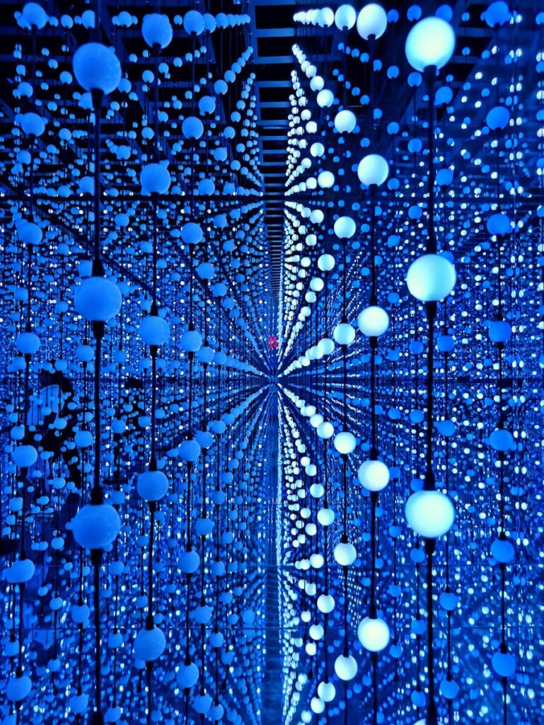 An immersive infinity room filled with countless glowing blue lights